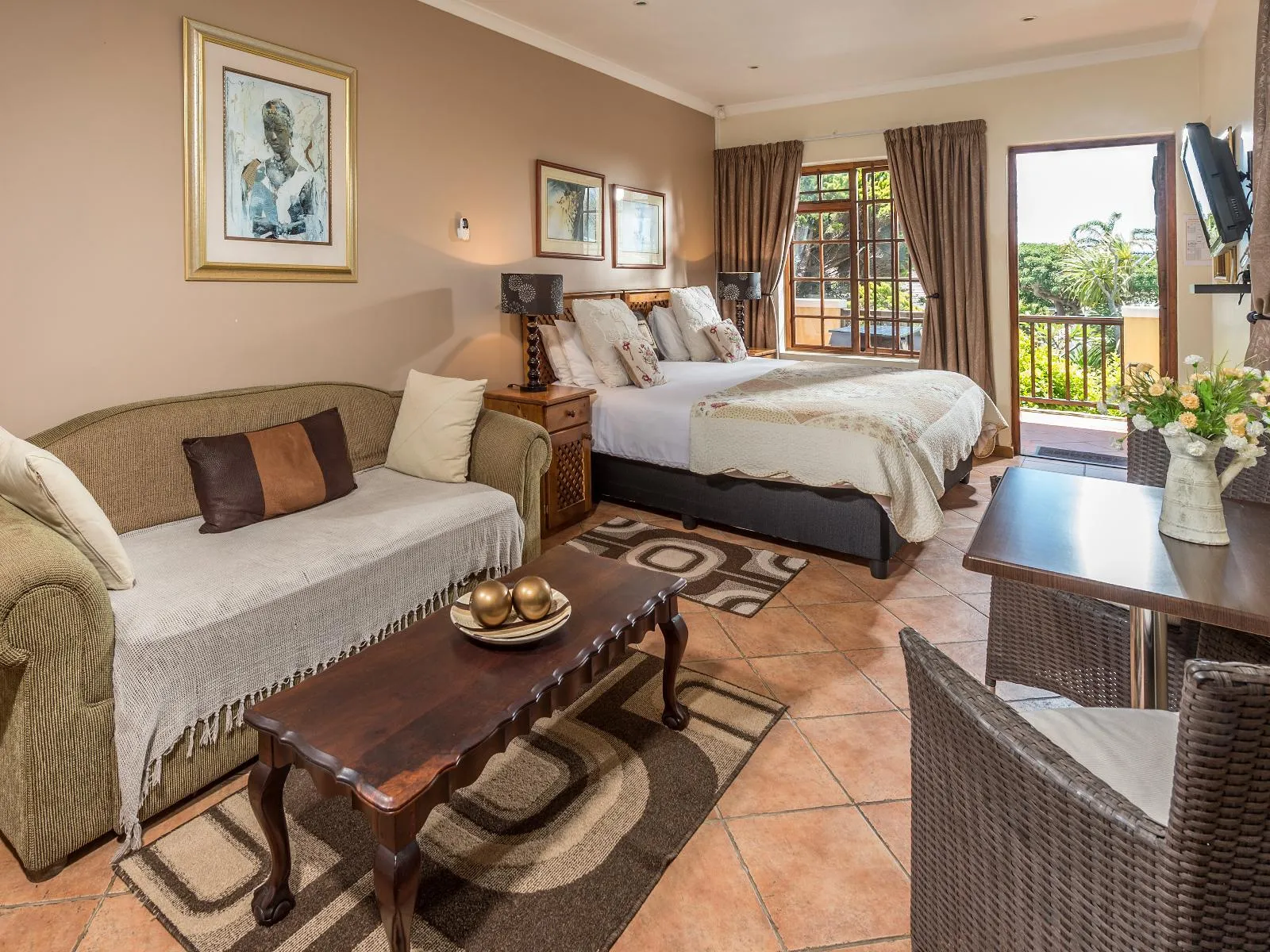 Cozy bedroom with sofa bed and balcony view decorated with art and plants