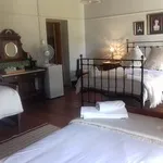 Cozy bedroom with two beds a mirror and a fan