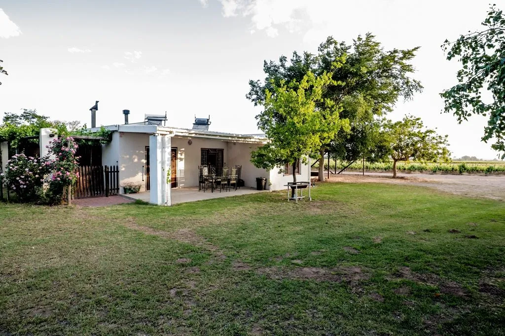 White house with garden trees and patio furniture in a rural setting