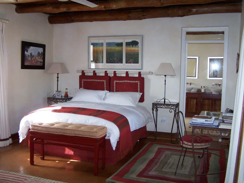 Cozy bedroom with red and white decor wooden beams and adjacent bathroom