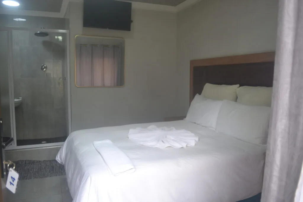 Small bedroom with a double bed and an adjacent shower