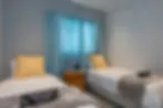 Blurry image of a bedroom with two single beds and a nightstand