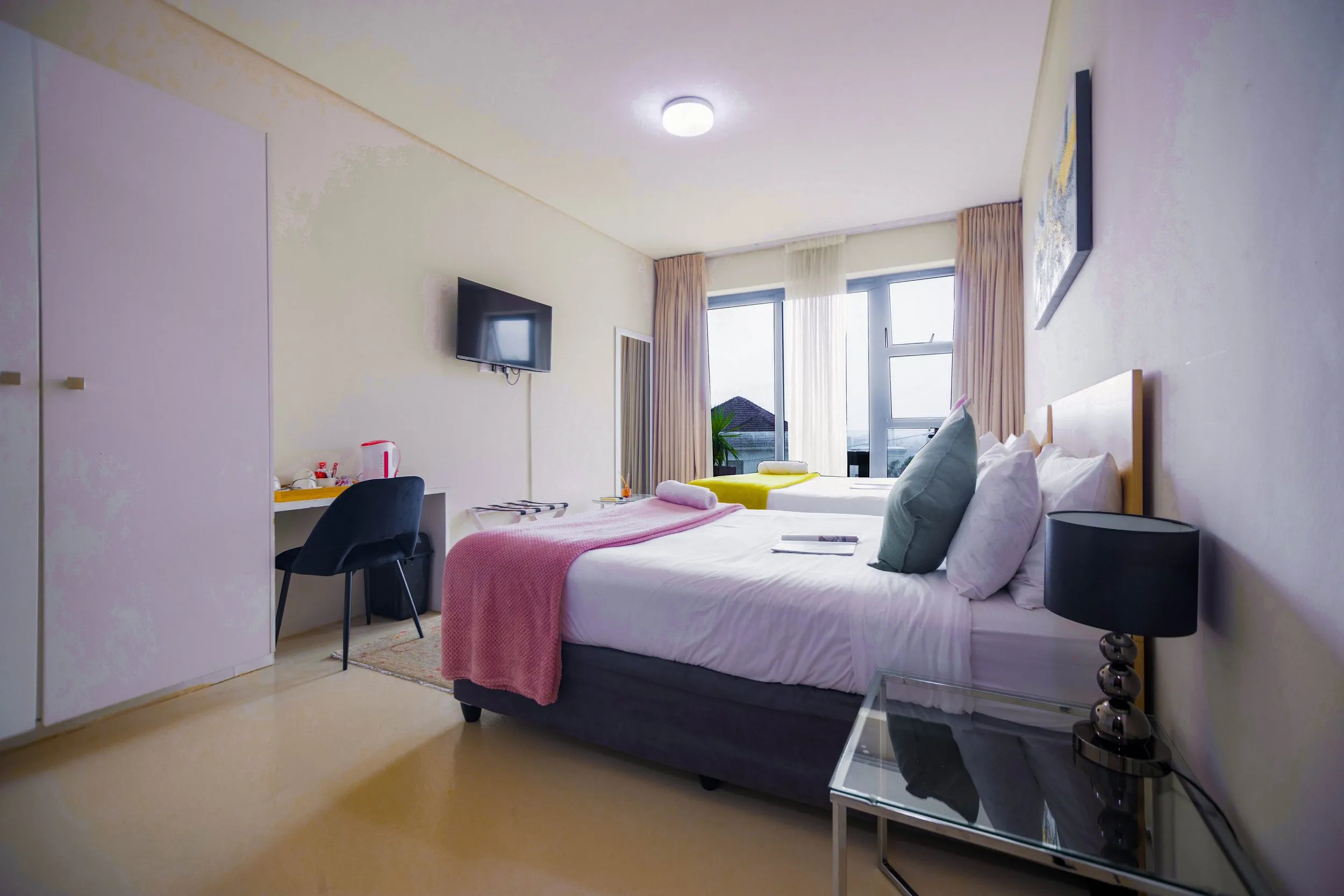 Modern hotel room with bed desk TV and large windows