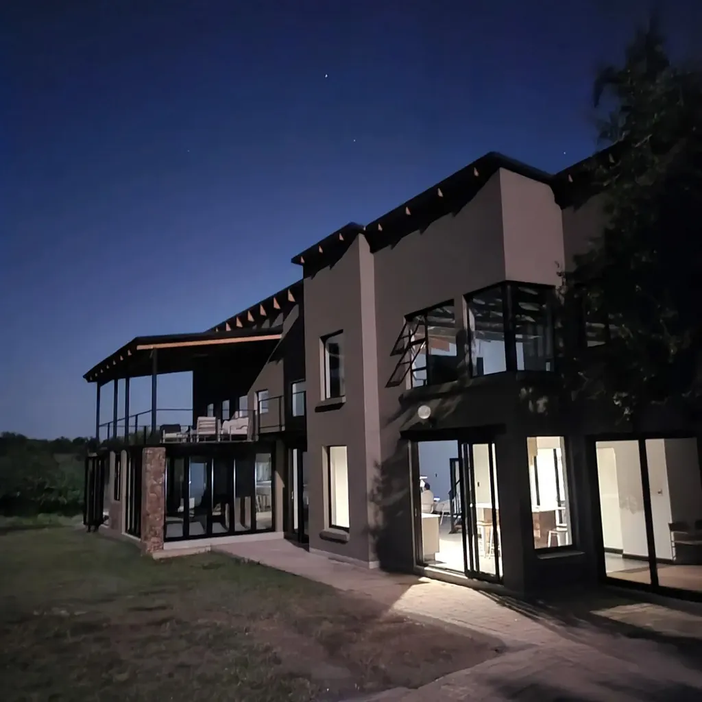 Modern house at night with illuminated windows and outdoor patio