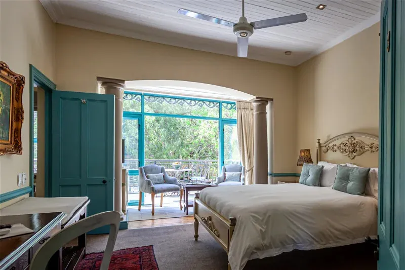 Bedroom with large bed balcony access and ceiling fan
