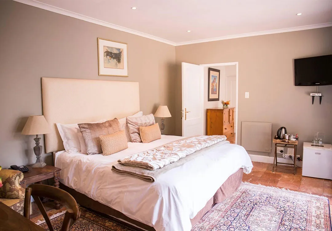 Cozy bedroom with a large bed bedside lamps and a TV on the wall