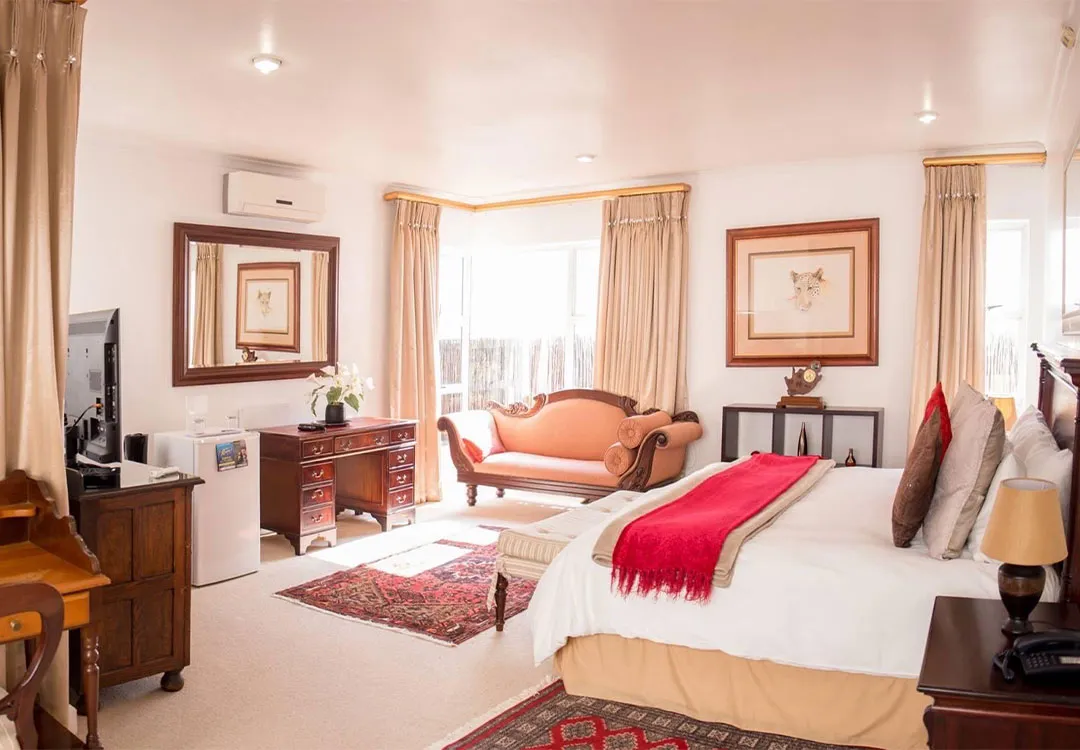 Cozy bedroom with a large bed red throw and vintage furniture