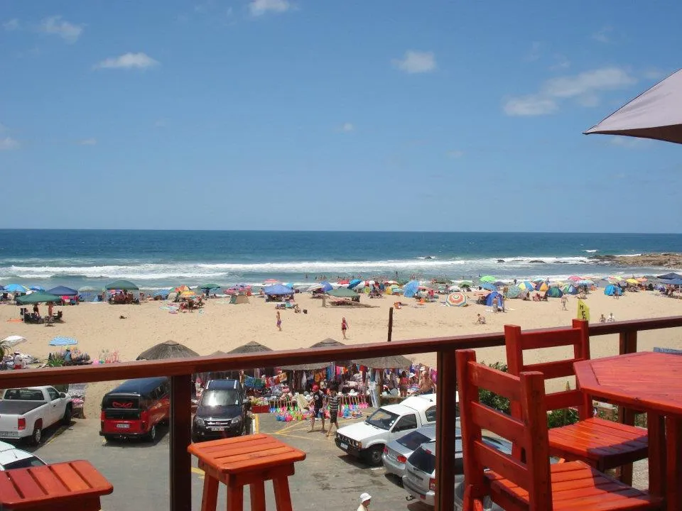 Beach scene with colorful umbrellas people and ocean view from a balcony