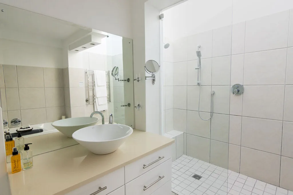 Modern bathroom with white sink mirror and tiled shower area
