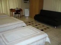 Hotel room with two beds sofa desk and refrigerator