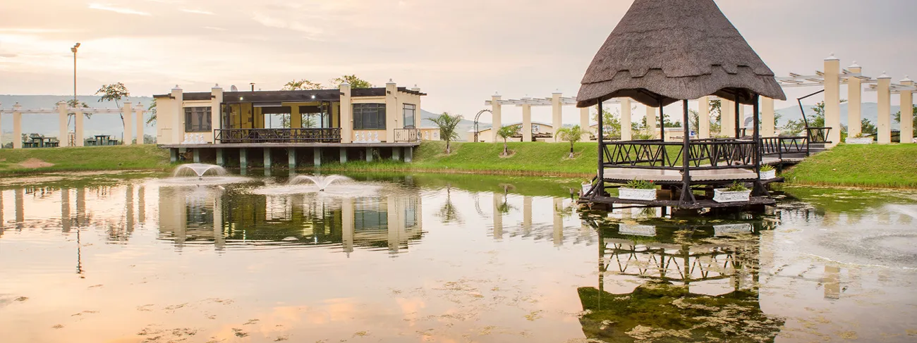 Modern building and gazebo by a pond at sunset with reflections on water