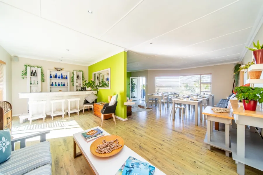 Bright dining area with tables chairs and a bar in a modern home