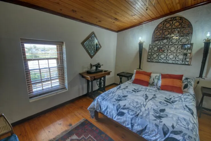 Cozy bedroom with wooden ceiling floral bedspread and vintage decor