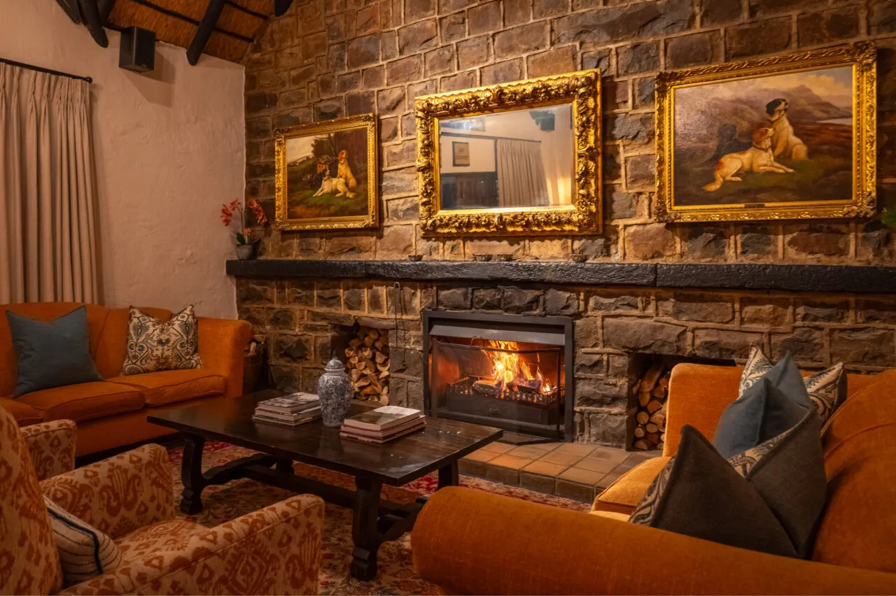 Cozy living room with fireplace sofas and framed paintings on stone wall