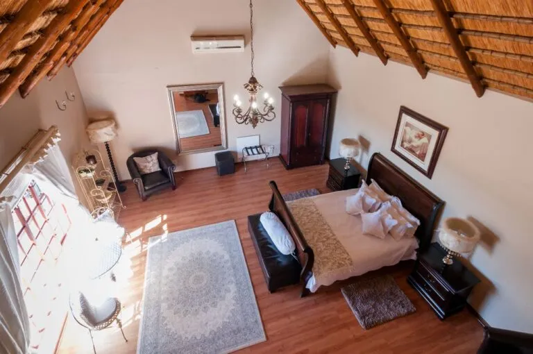 Cozy bedroom with wooden ceiling large bed and traditional decor