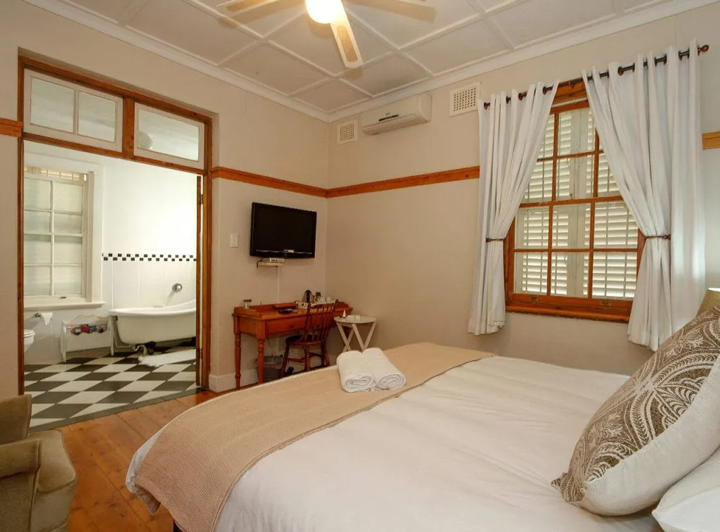 Cozy bedroom with a bed desk and view of a black and white bathroom
