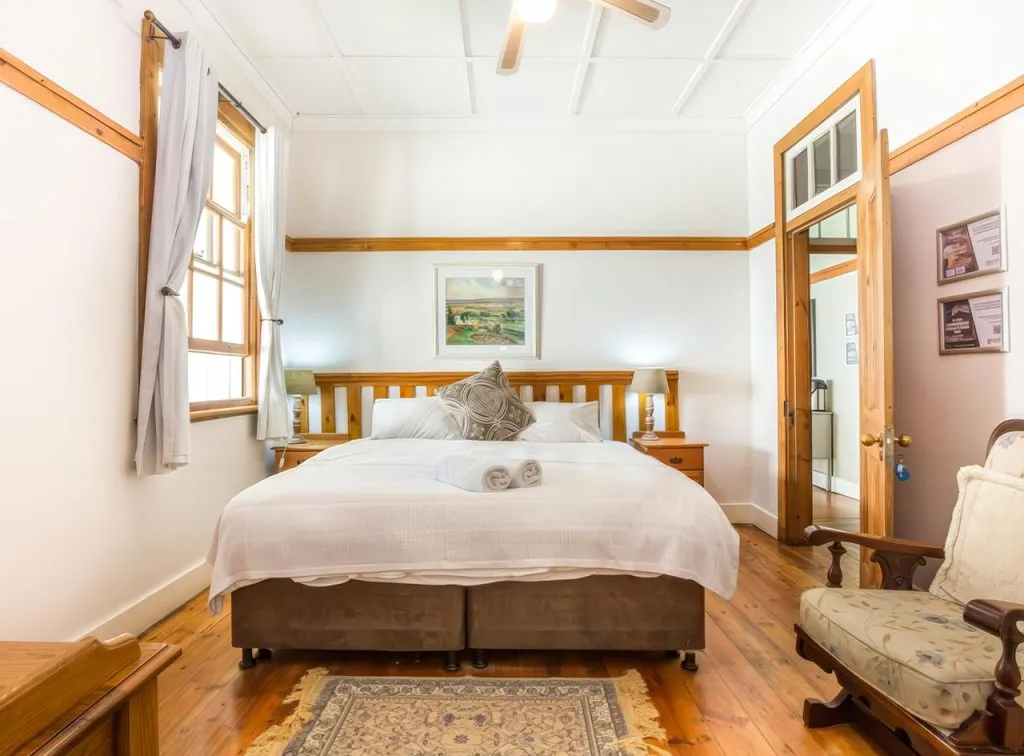 Cozy bedroom with wooden furniture white bed and ceiling fan