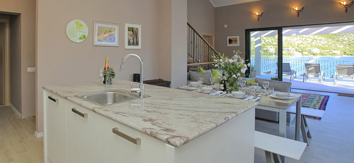 Modern kitchen with island open to dining area and outdoor view