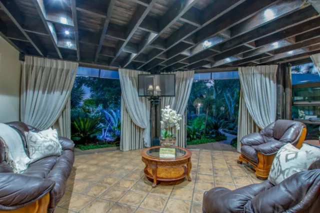 Cozy living room with leather furniture and large windows overlooking a garden