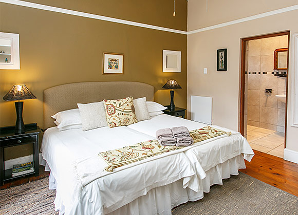 Cozy bedroom with a large bed, bedside lamps, and an adjacent bathroom.
