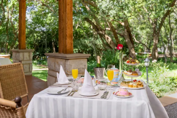 Outdoor breakfast table with pastries juice and a scenic garden background