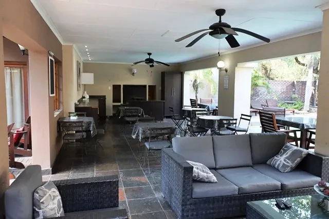 Indooroutdoor lounge area with tables chairs and ceiling fans