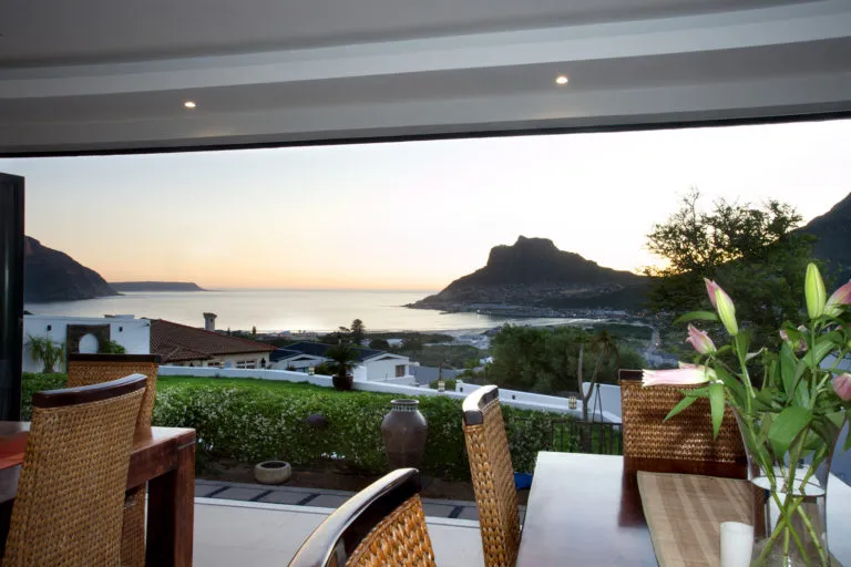 Dining area with ocean view mountains and flowers on the table