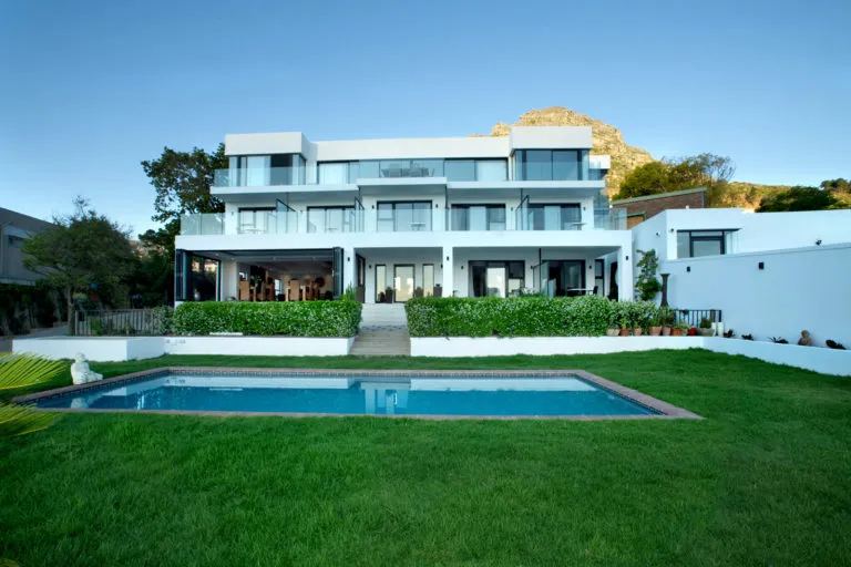 Modern threestory house with pool and garden mountain in background