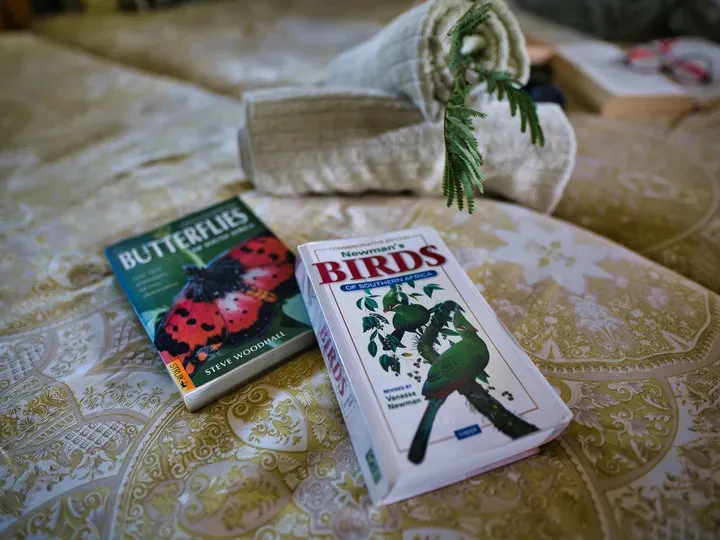 Two books on a bed one about butterflies and one about birds