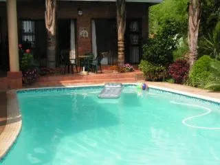 Swimming pool with inflatable lounger and toys in a garden setting