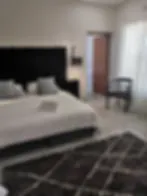 Blurry bedroom with a bed nightstand chair and patterned rug