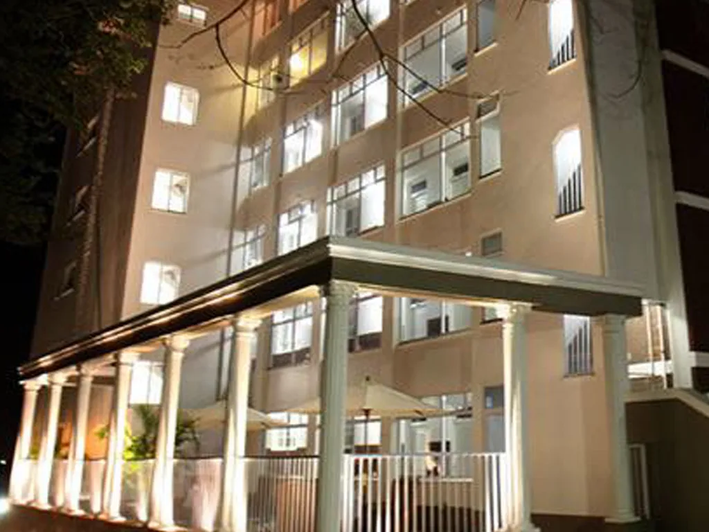 Night view of a multistory building with lit windows and a covered entrance
