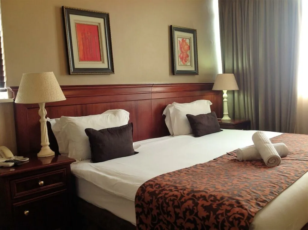 Hotel room with a neatly made bed bedside tables and lamps