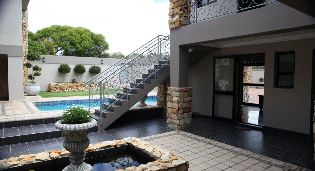 Modern courtyard with pool staircase and stone fountain