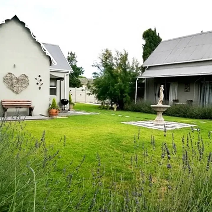 Cottage and garden with a fountain and lavender in the foreground