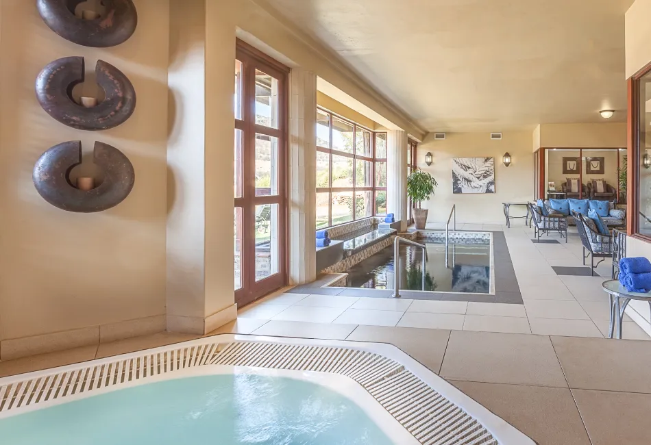 Indoor spa area with hot tub pool and lounge seating near large windows