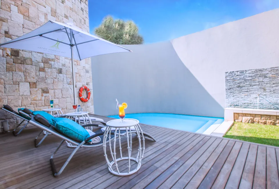Sun loungers and a drink by a small pool with stone walls