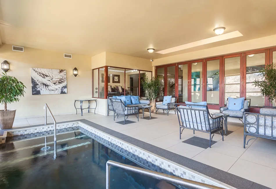 Indoor pool area with seating plants and large windows