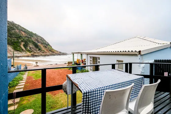 Beach view from a balcony with a table and chairs
