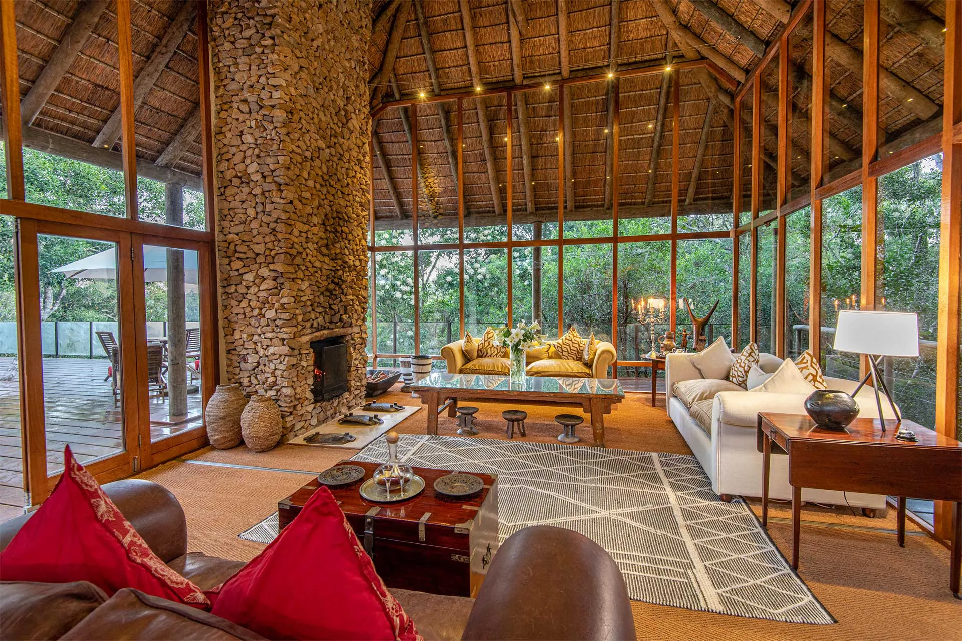 Cozy living room with large windows wooden beams and stone fireplace