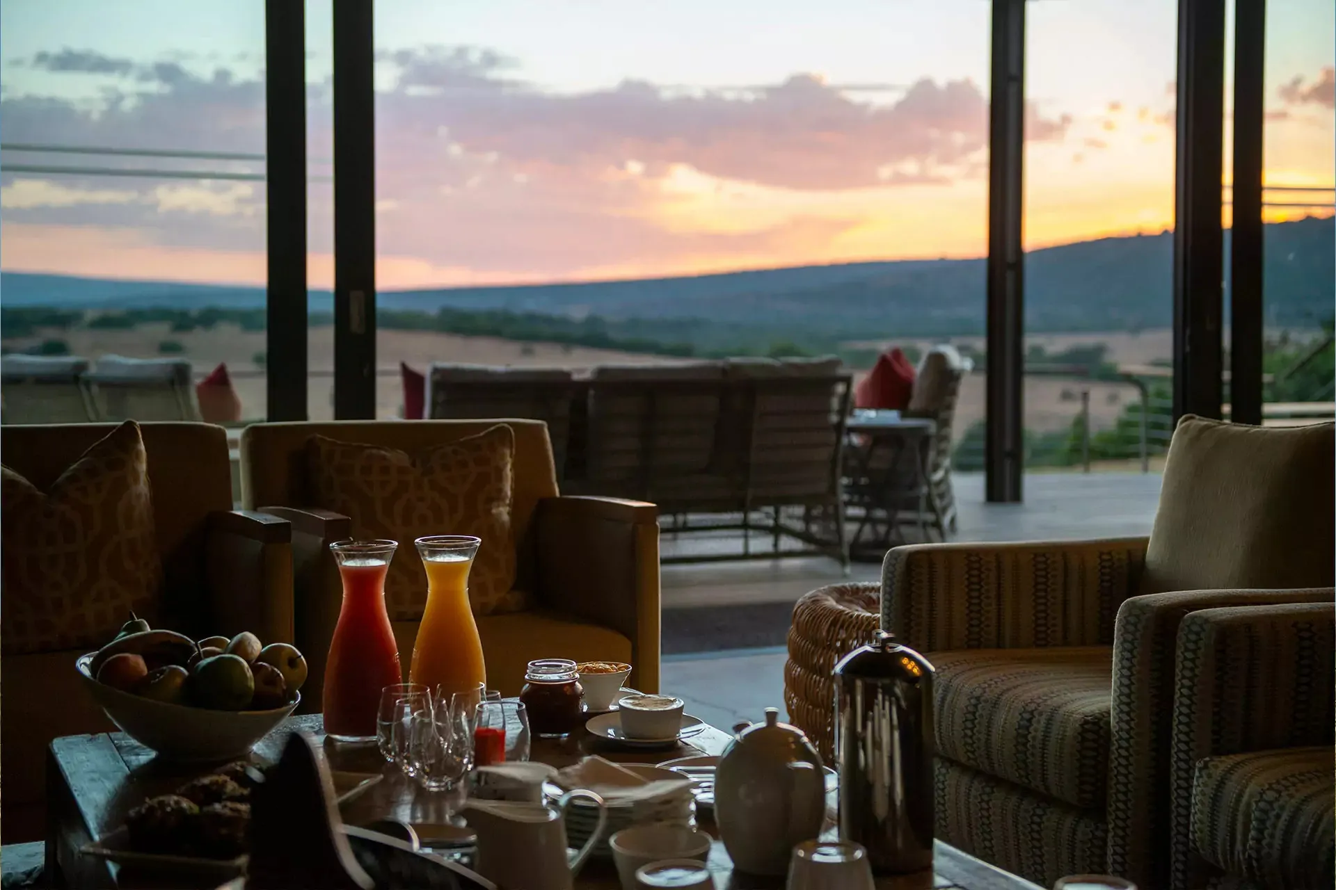 Cozy lounge with a view of sunset through large windows breakfast setup on table