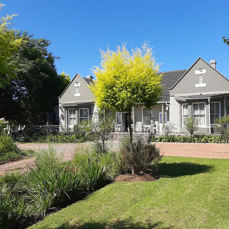 A charming house with a garden and pathway on a sunny day