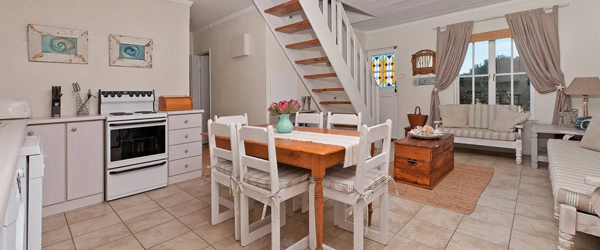 Open kitchen and dining area with stairs leading to an upper level