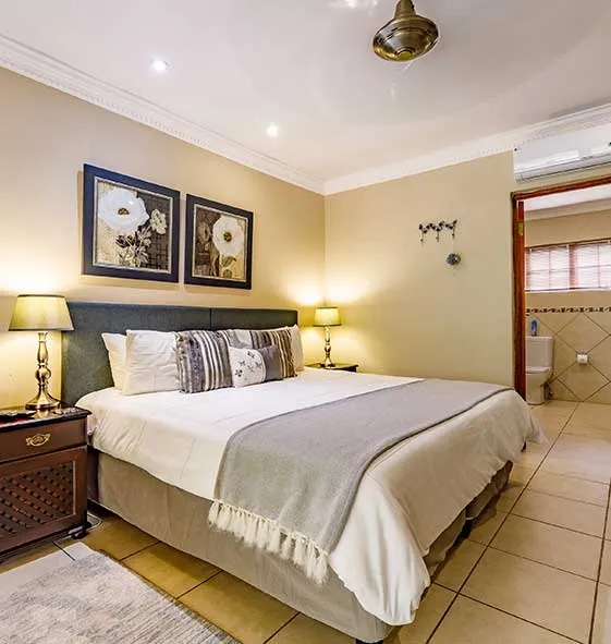 Modern bedroom with a large bed artwork and an attached bathroom