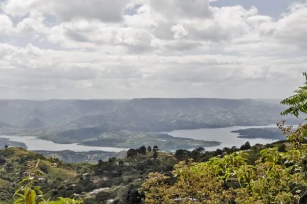 Scenic view of a lake surrounded by hills and lush greenery