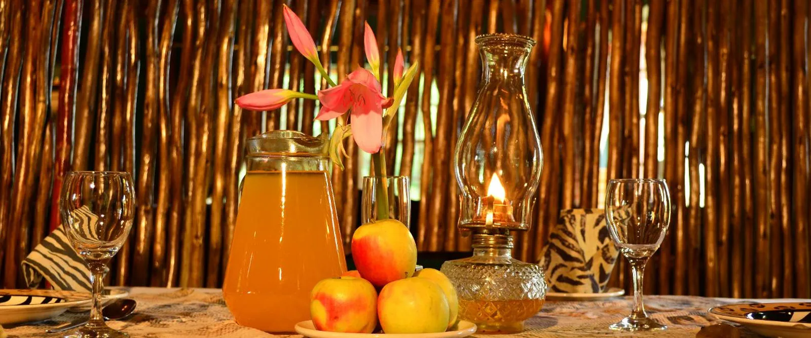 Wooden wall table with fruit juice wine glasses and an oil lamp