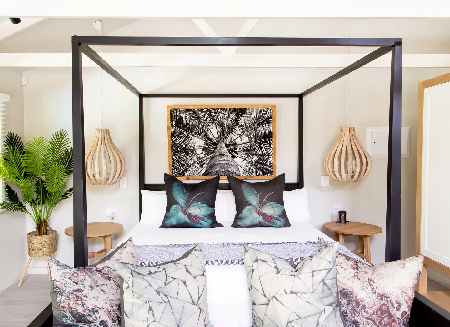 Bedroom with a fourposter bed tropical decor and pendant lights