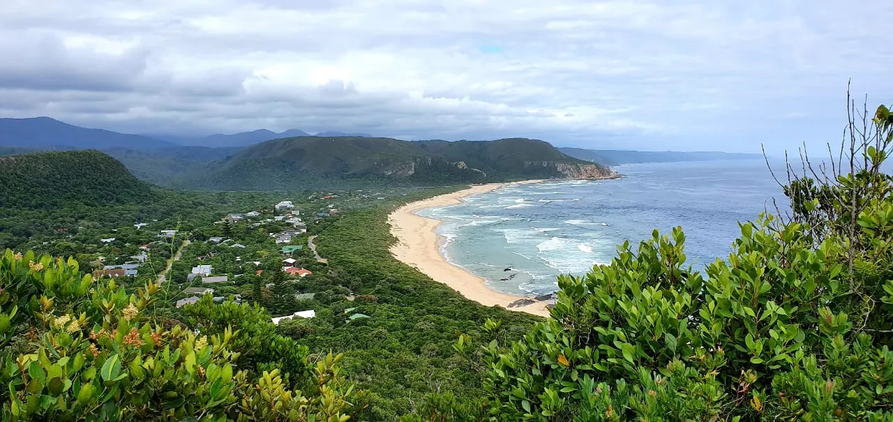 Coastal town with sandy beach green hills and ocean waves