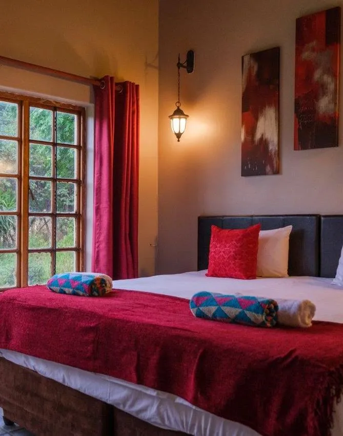 Cozy bedroom with red decor large window and bedside lamp