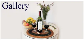 Wine bottle and glasses on a tray with fruit and flowers in the background